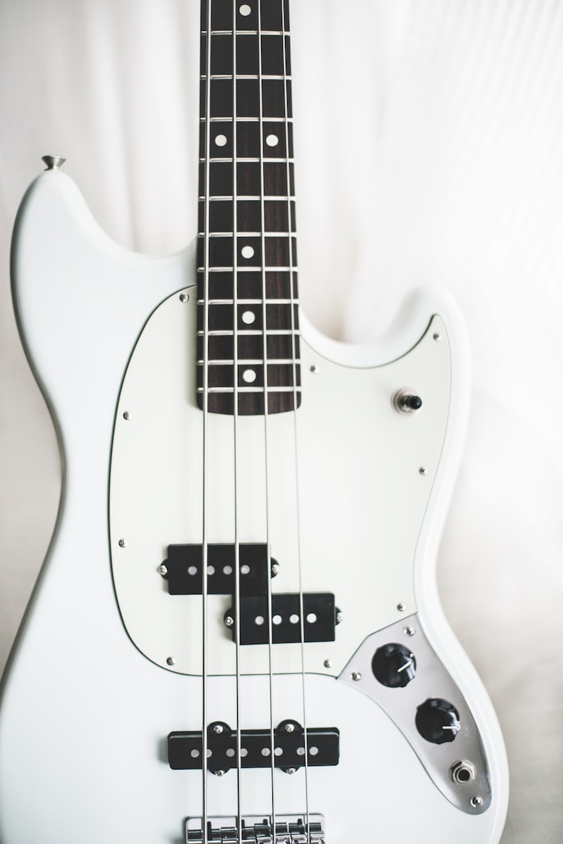 Photo by Kari Shea white and black electric bass guitar on white surface